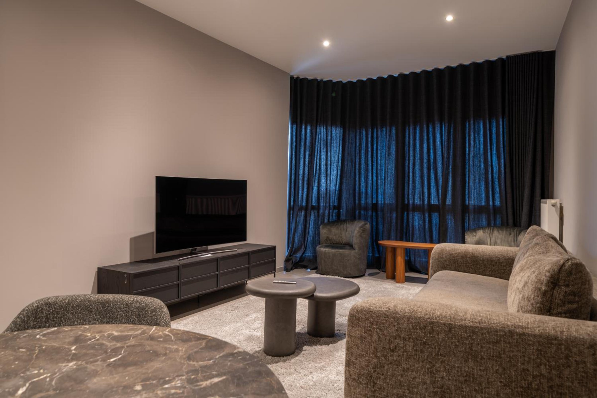 Salon lumineux avec canapé et télévision – The Edgewater Suites Cityscape, Namur