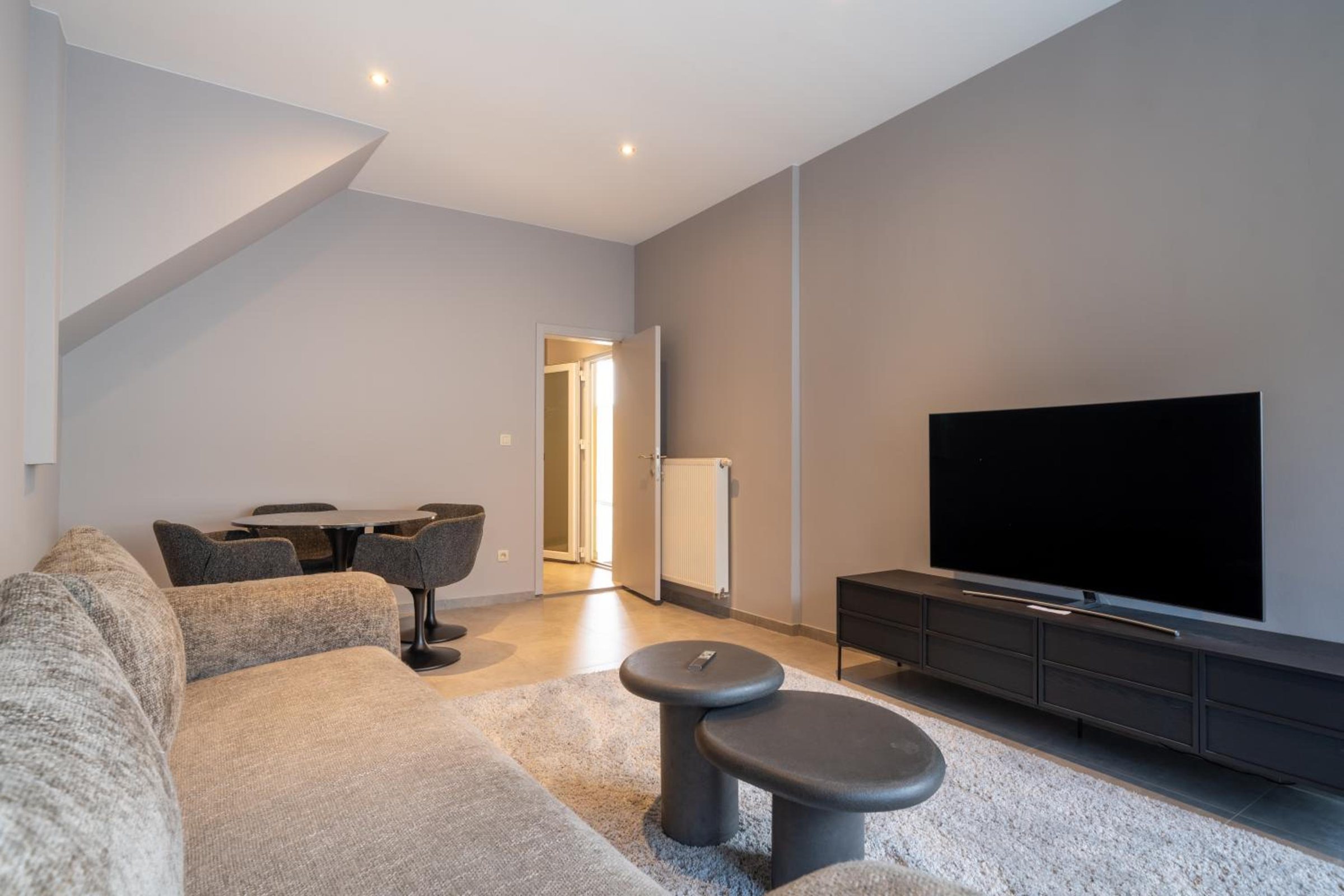 Salon lumineux avec canapé et télévision – The Edgewater Suites Cityscape, Namur