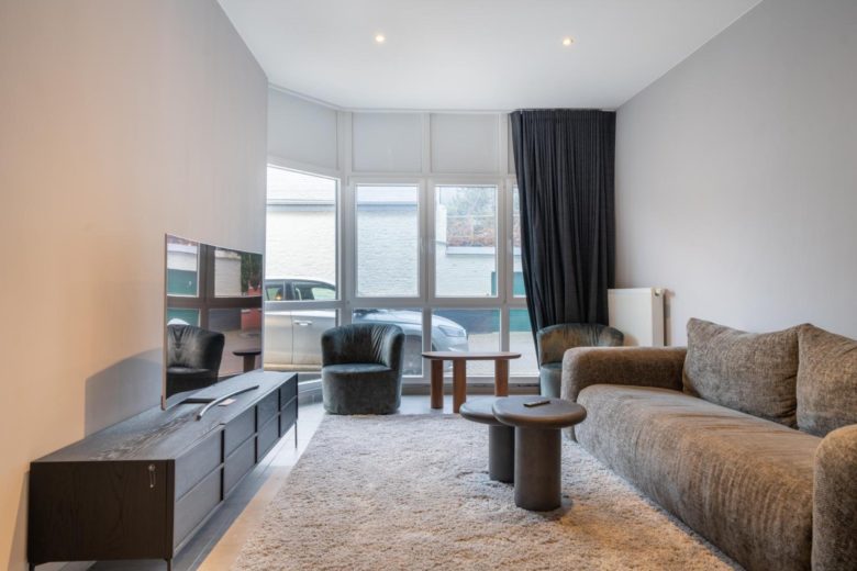 Salon lumineux avec canapé et télévision – The Edgewater Suites Cityscape, Namur