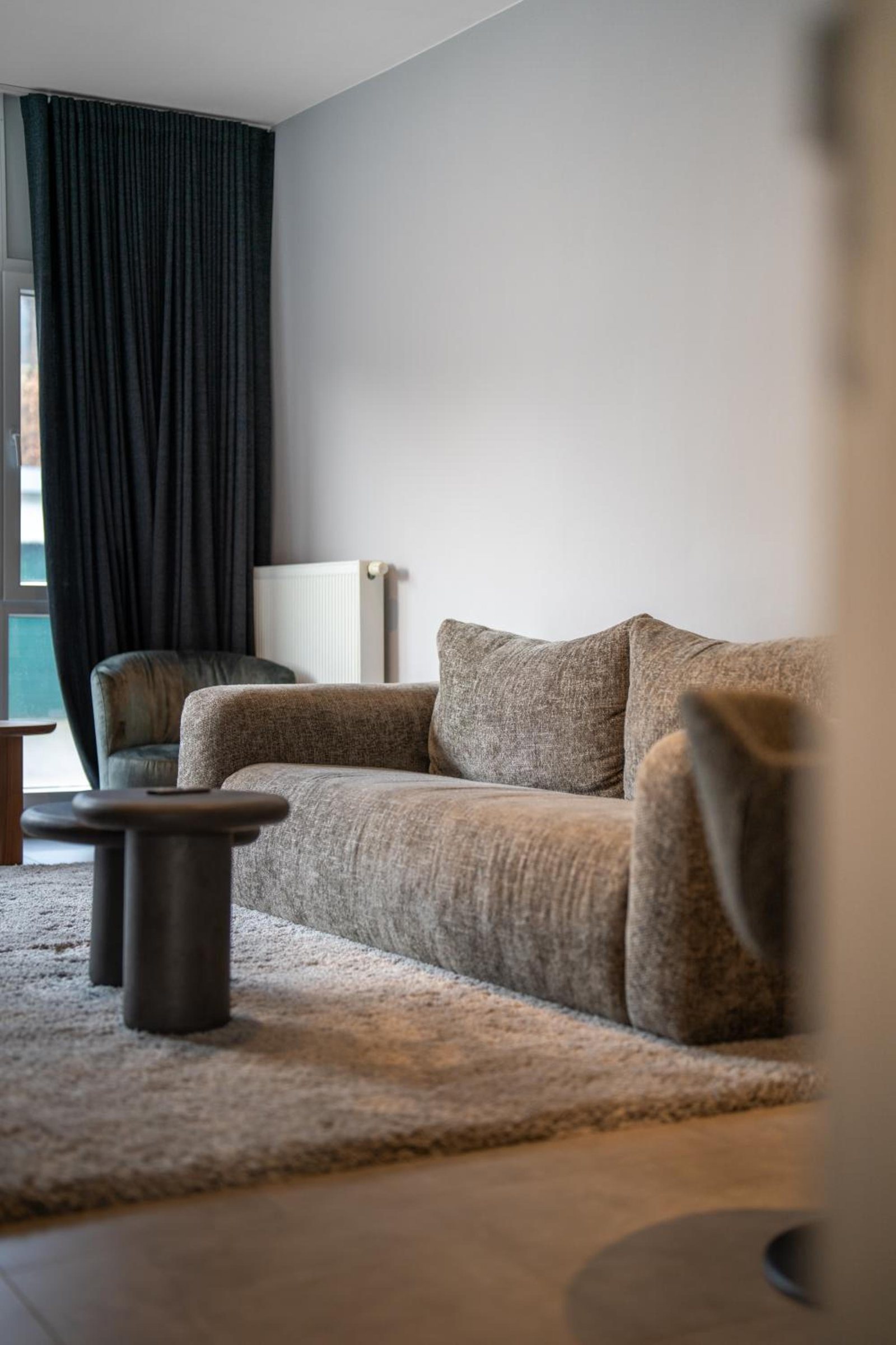 Salon lumineux avec canapé et télévision – The Edgewater Suites Cityscape, Namur