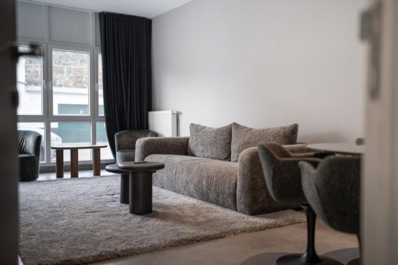 Salon lumineux avec canapé et télévision – The Edgewater Suites Cityscape, Namur