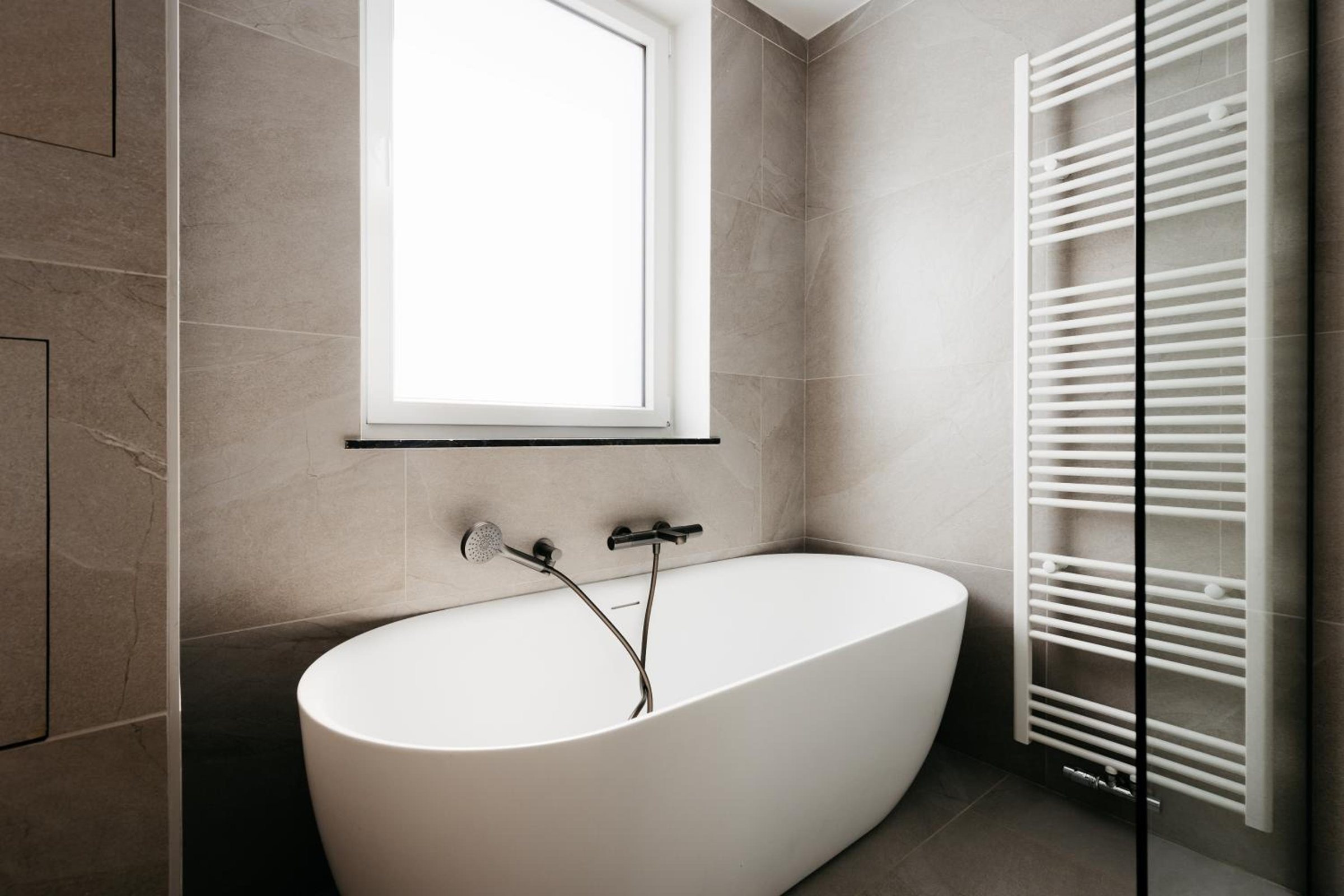 Salle de bains avec baignoire îlot et douche – The Edgewater Suites ParkView, Namur