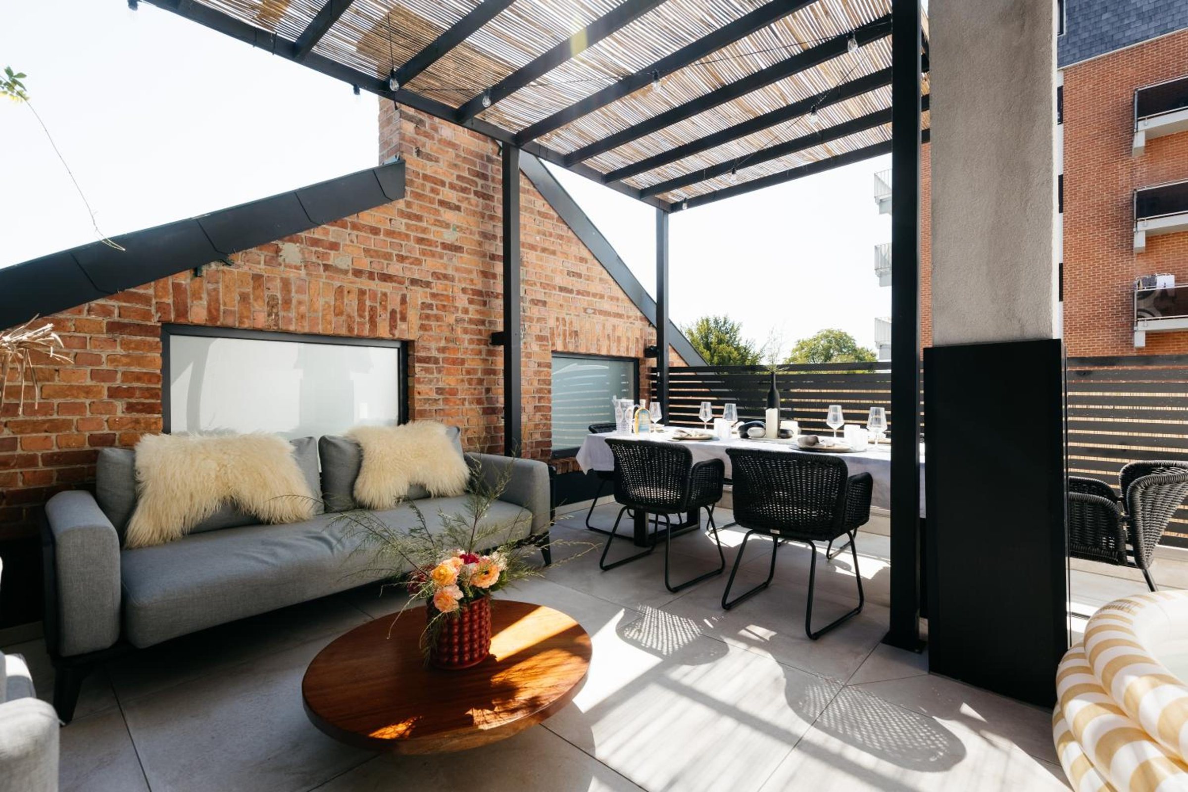 Grande terrasse couverte avec salon et table extérieure – The Edgewater Suites ParkView, Namur