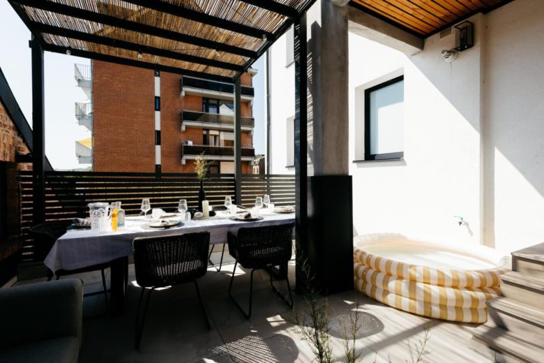 Grande terrasse couverte avec salon et table extérieure – The Edgewater Suites ParkView, Namur