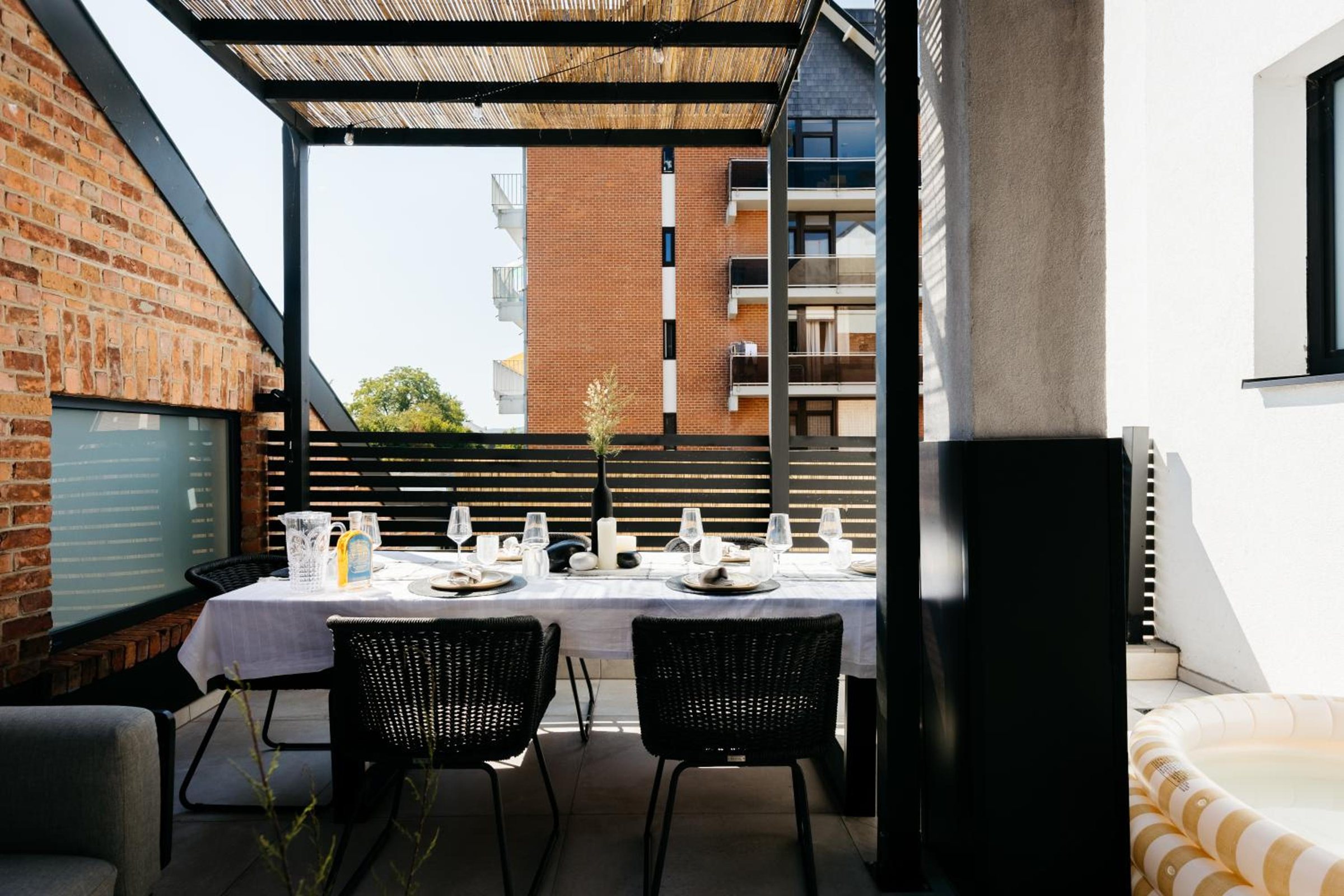 Grande terrasse couverte avec salon et table extérieure – The Edgewater Suites ParkView, Namur