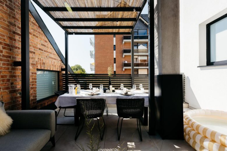 Grande terrasse couverte avec salon et table extérieure – The Edgewater Suites ParkView, Namur