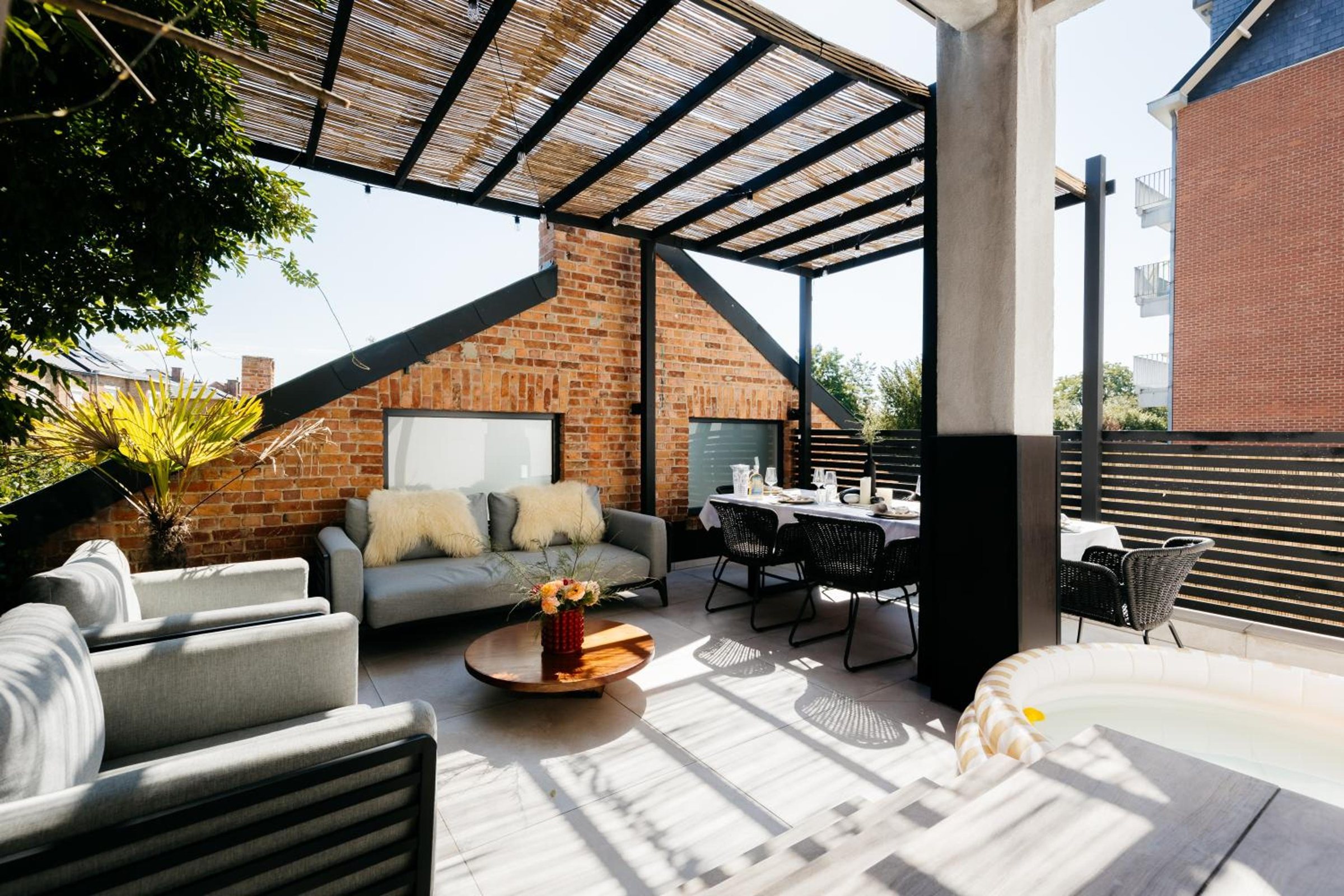 Grande terrasse couverte avec salon et table extérieure – The Edgewater Suites ParkView, Namur