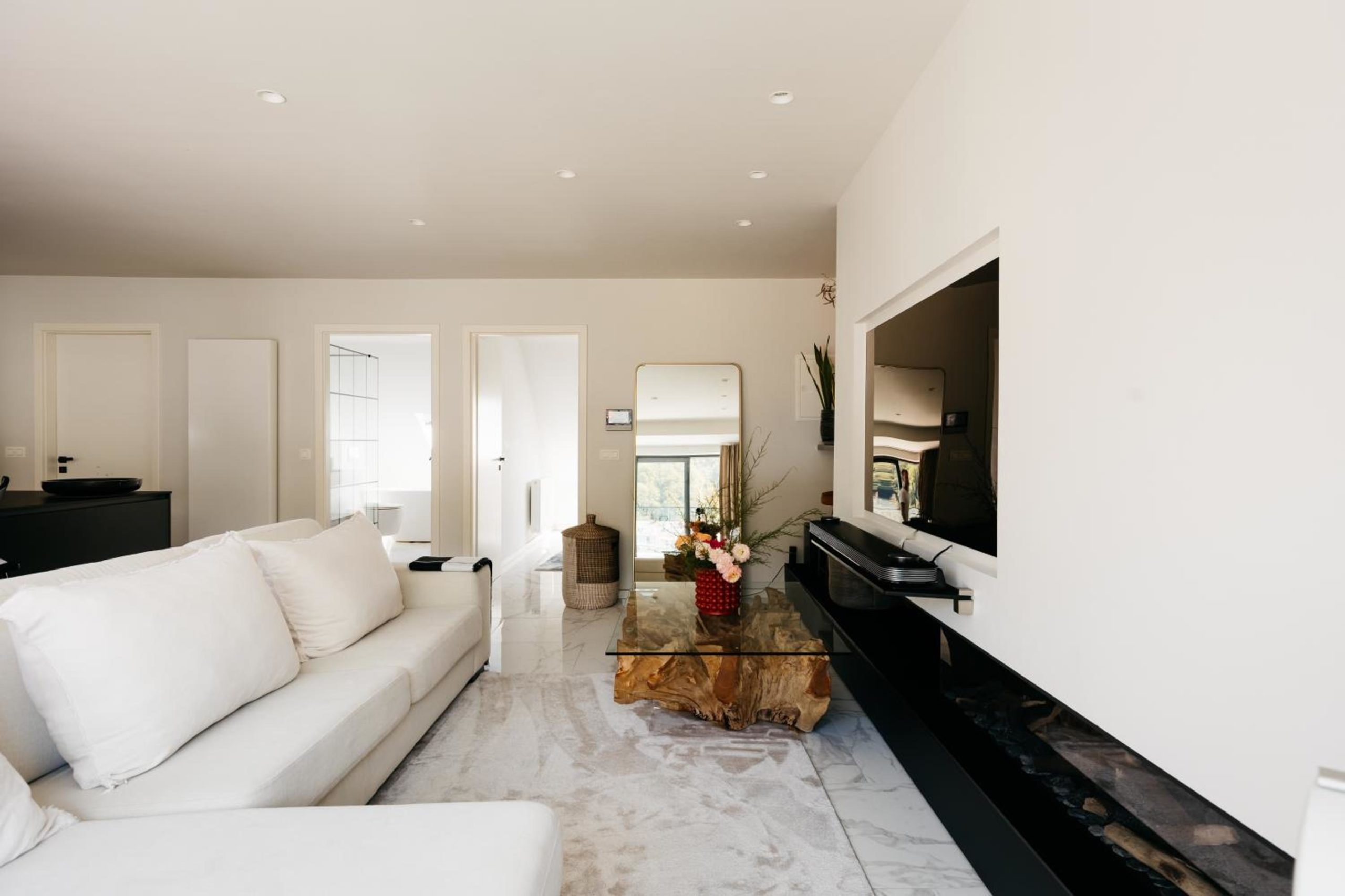 Salon lumineux avec canapé blanc – The Edgewater Suites Riverside, Namur