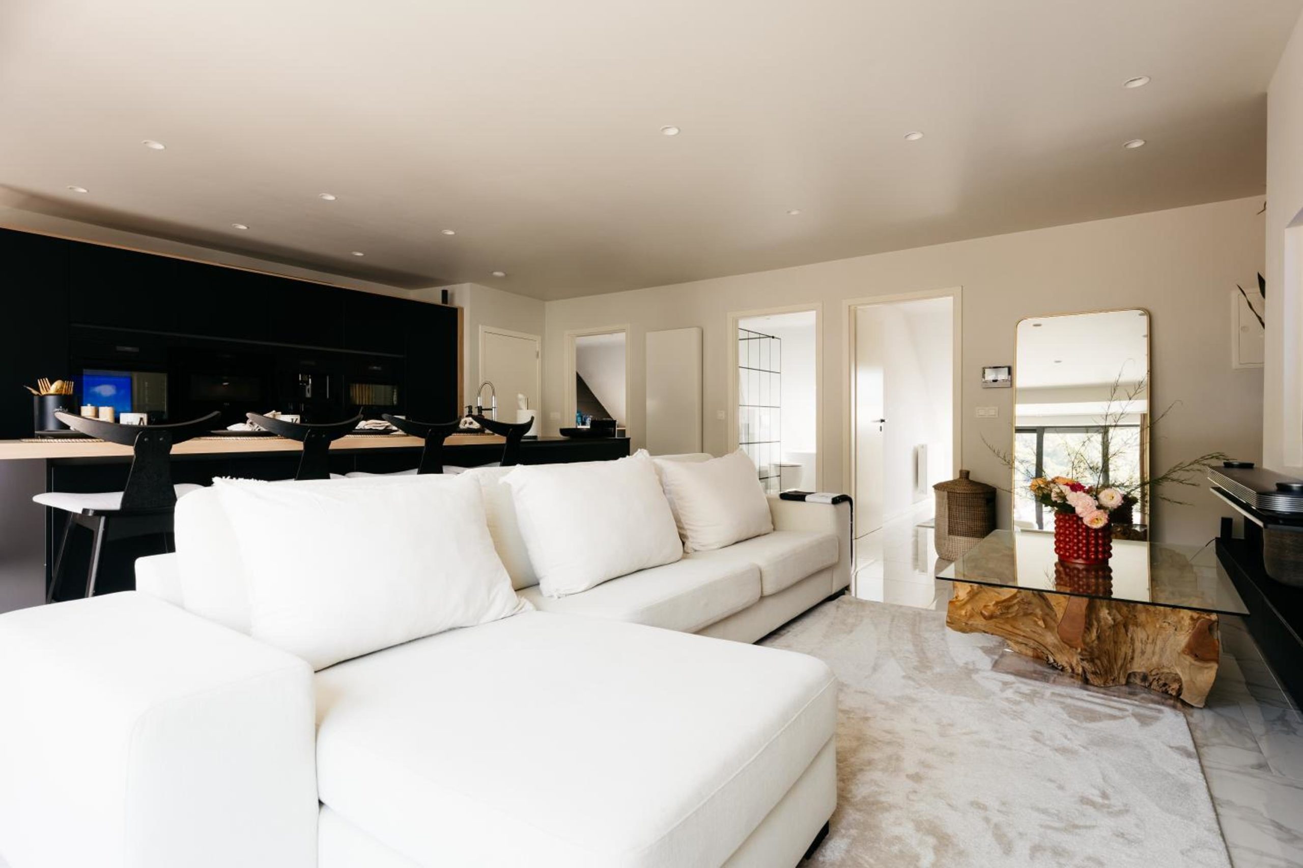 Salon lumineux avec canapé blanc – The Edgewater Suites Riverside, Namur
